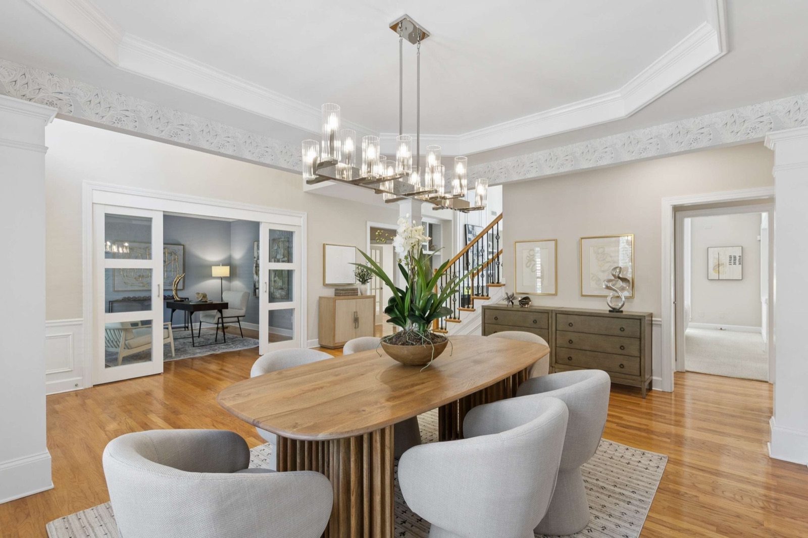 Formal dining room with a coffered ceiling and chandelier, staged for sale