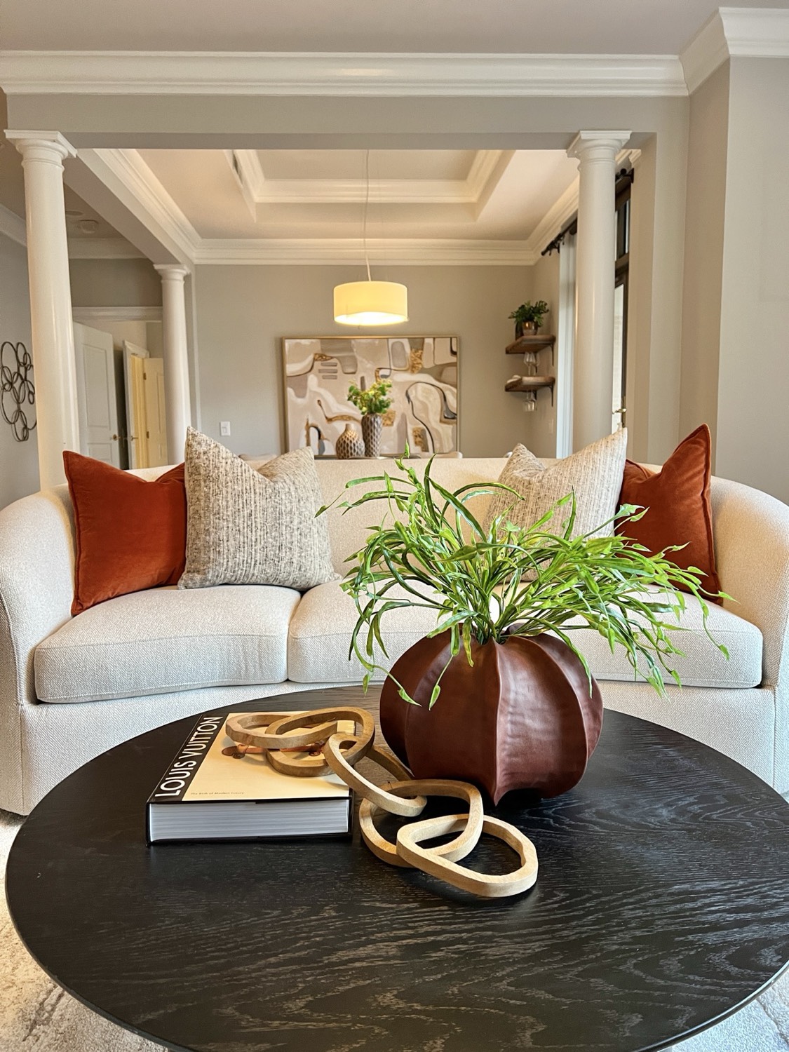Living room with warm accents and a sculptural coffee table, professionally staged